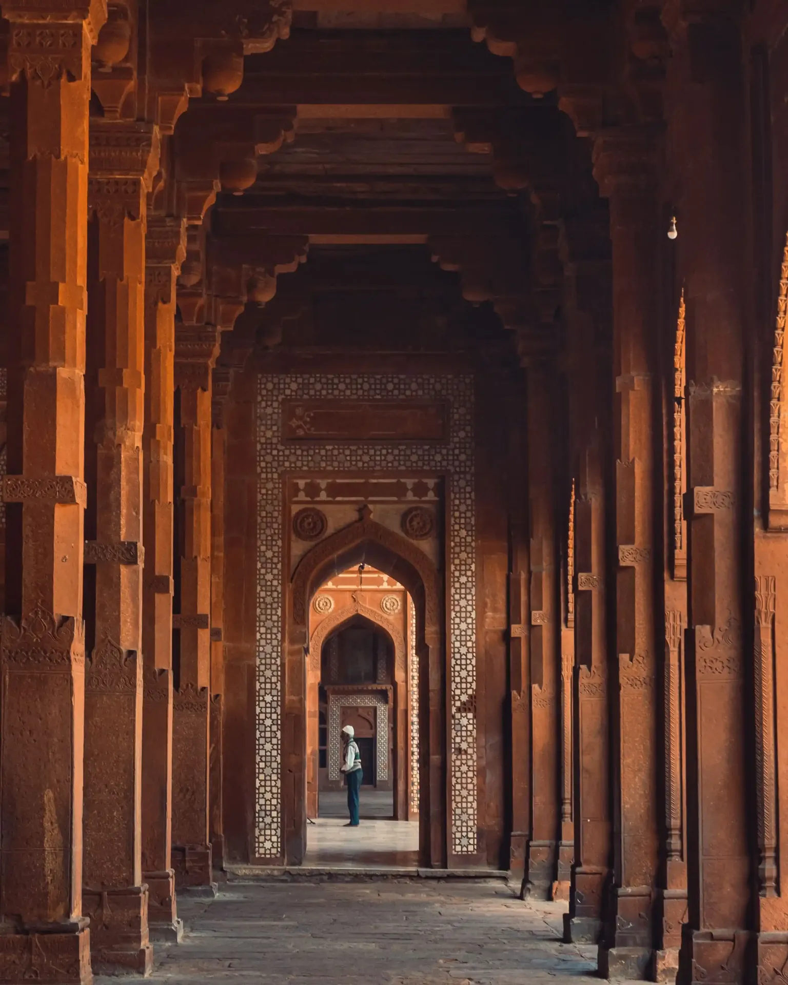 A long red sandstone arched corridor at Fatehpur Sikri