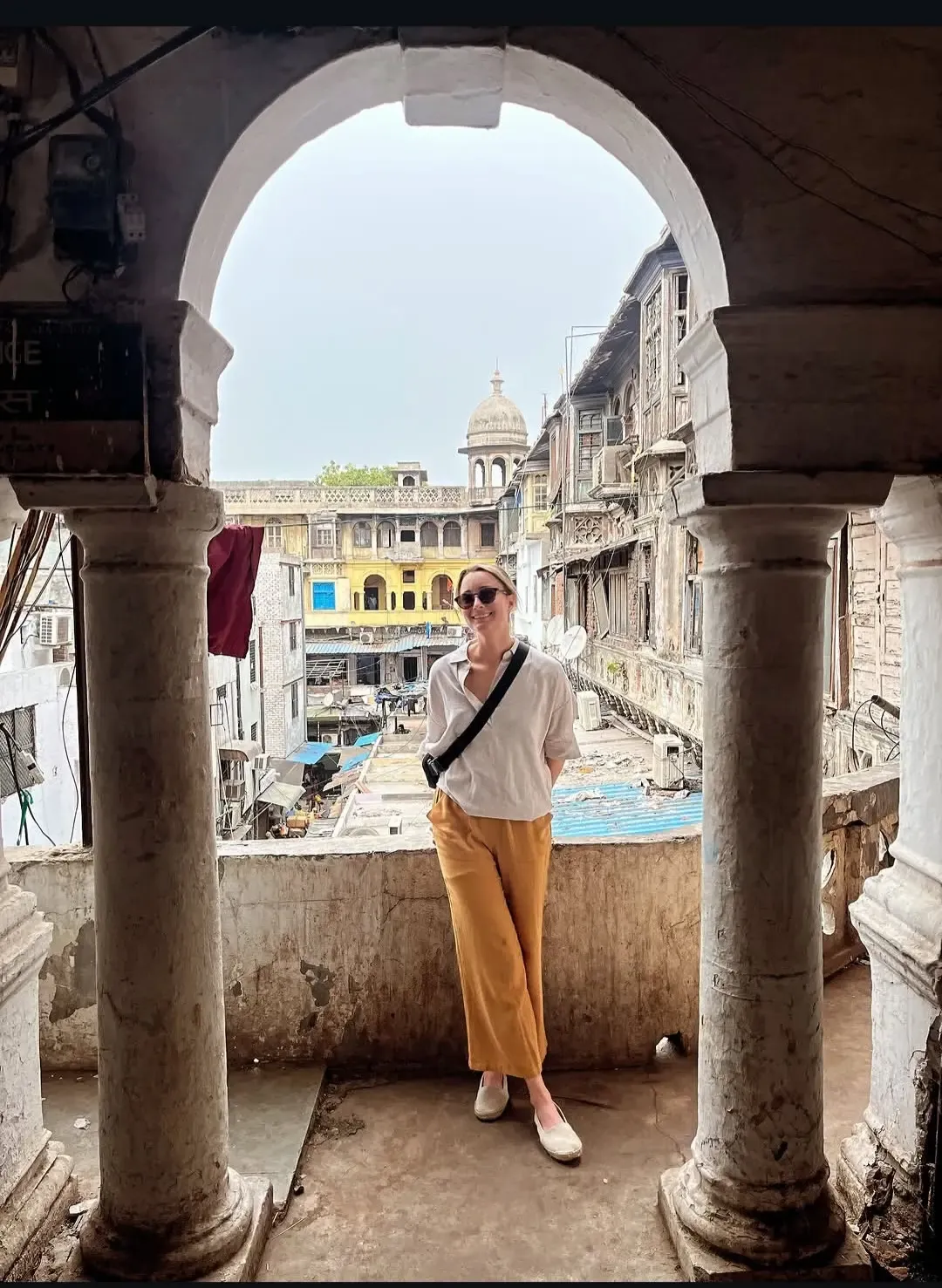 A traveller on an arched balcony overlooking Old Delhi