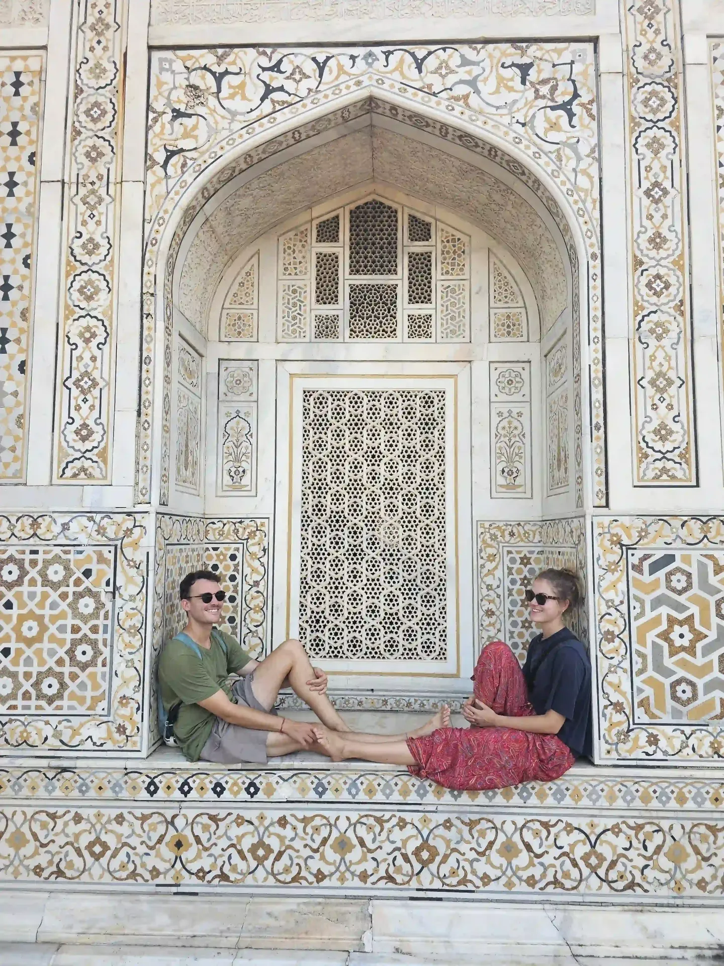 Two travellers resting on the carved marble plinth of the Taj Mahal